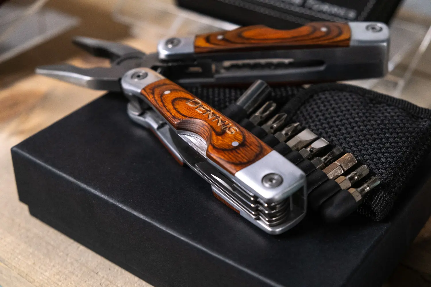 A pair of multitools are sitting on top of some other tools.