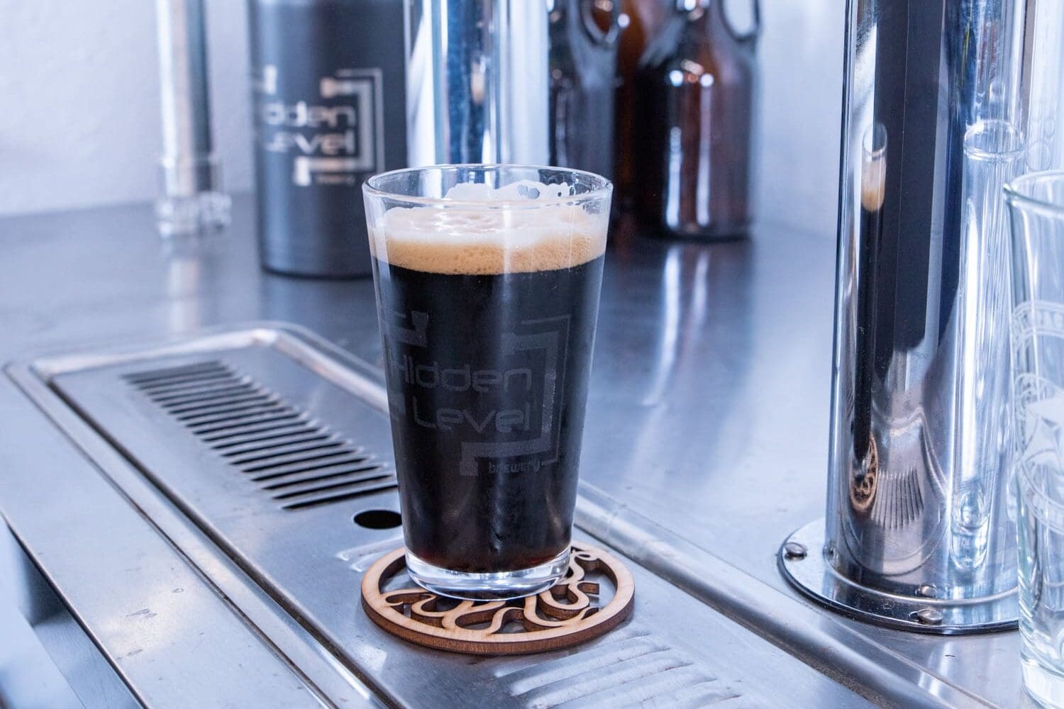 A glass of dark beer on top of a bar.