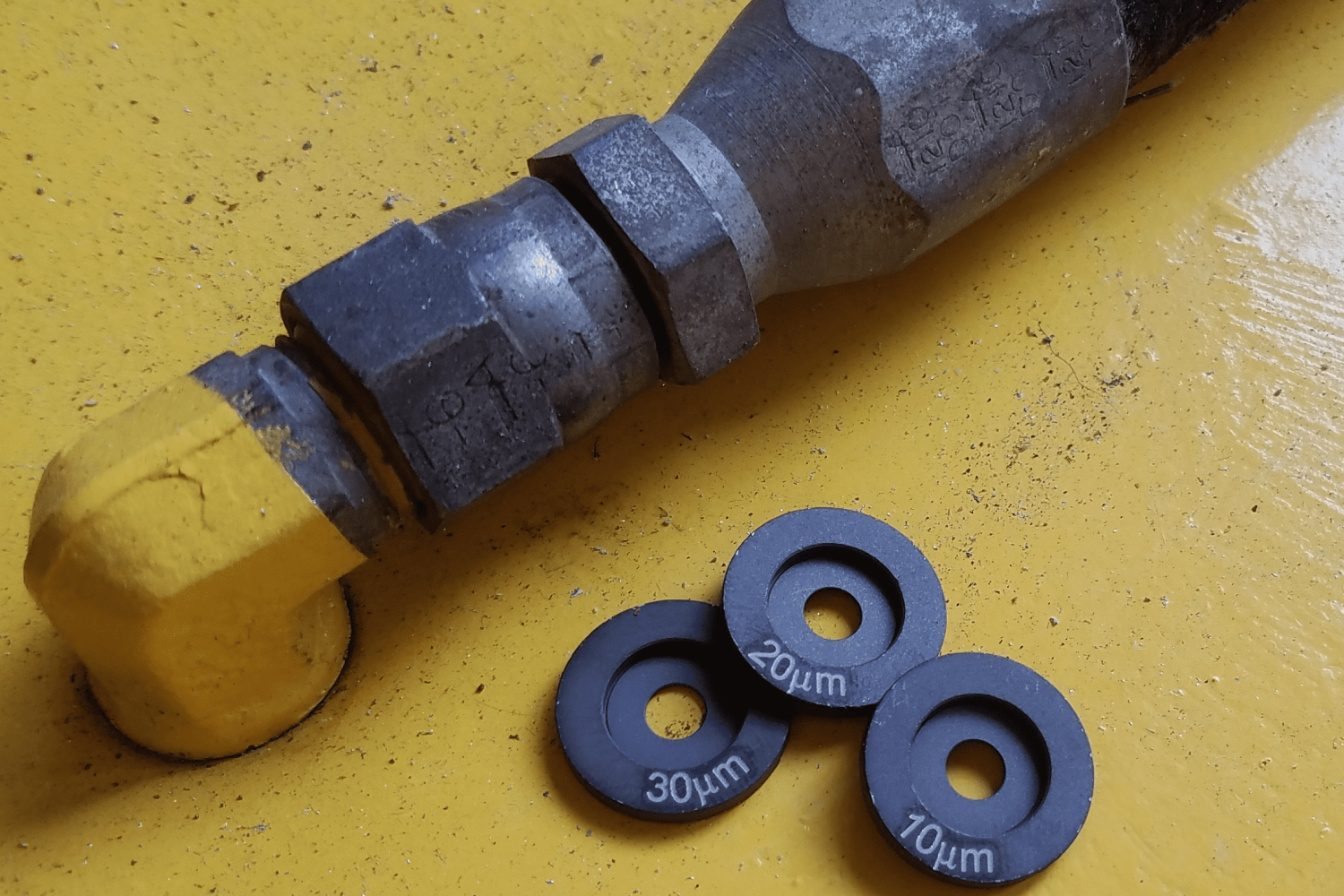 A close up of a pipe and some small metal washers