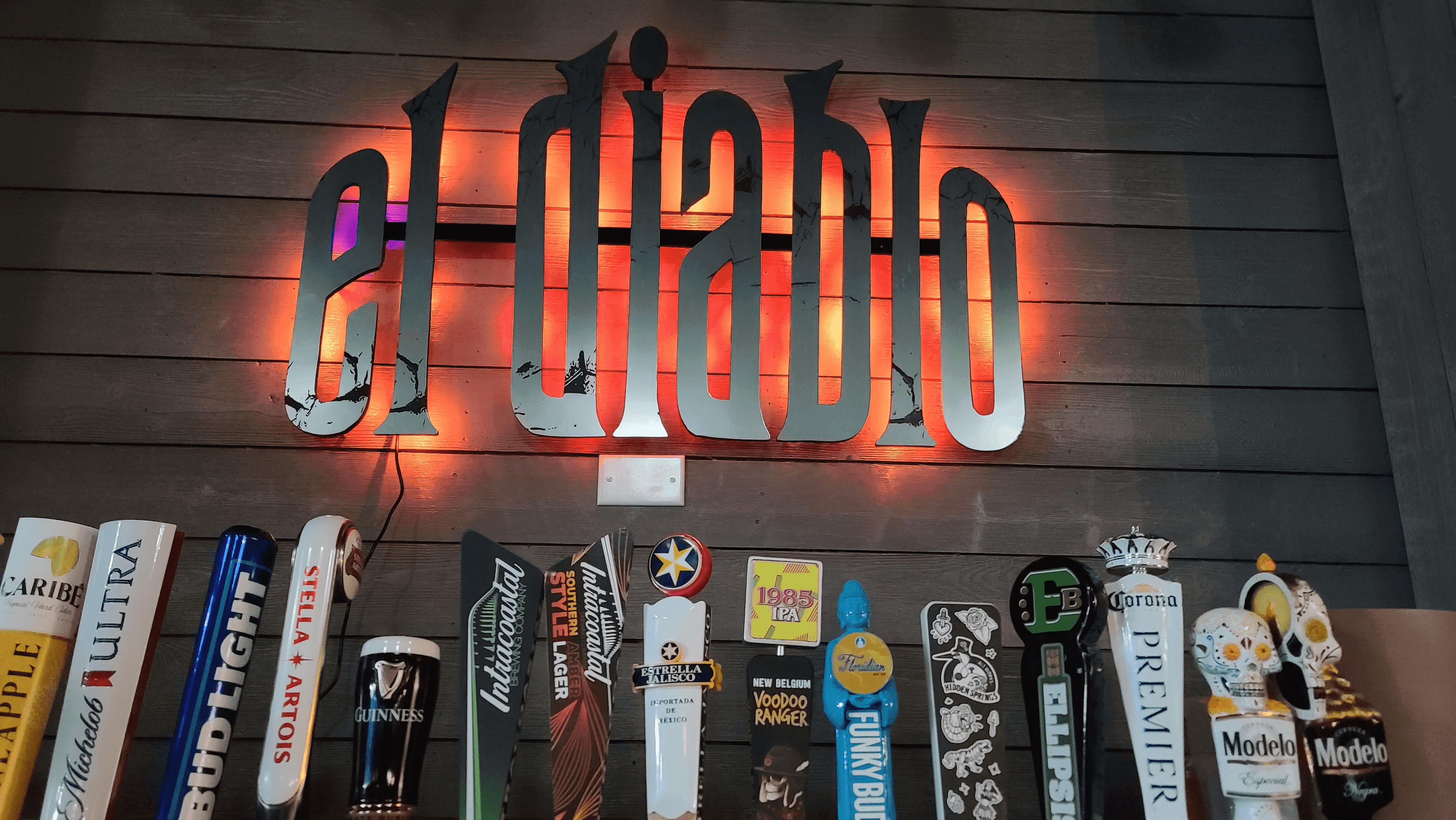 A wall with many different beers on it