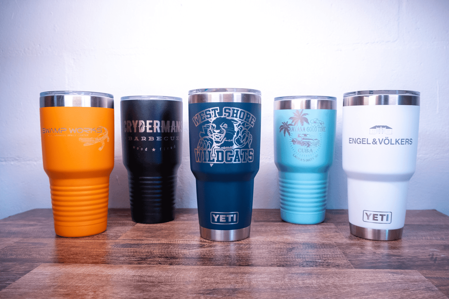 A group of five cups sitting on top of a wooden table.